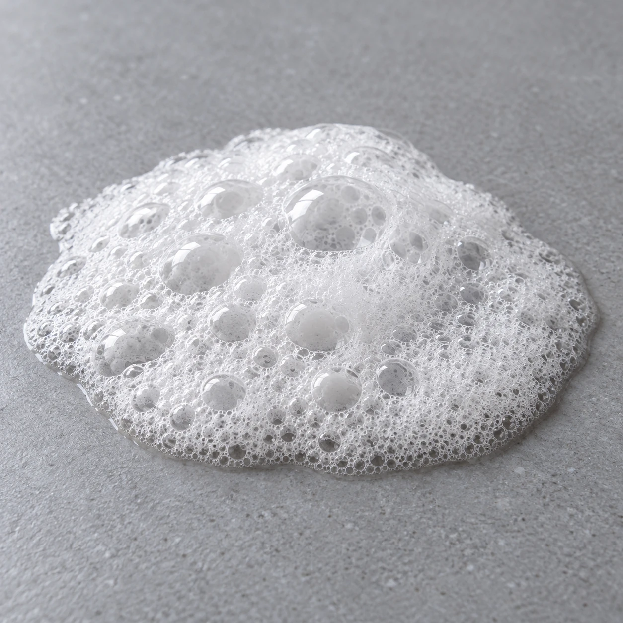 One cleanser foam cluster with bubbles of different sizes on a plain surface